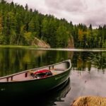 Green Canoe on a calm and serene lake with a peaceful view in Nuuksio in Finland.