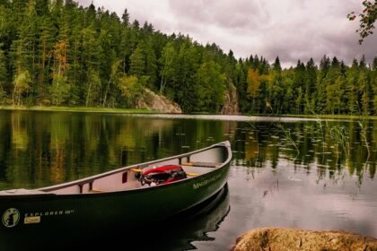 Green Canoe on a calm and serene lake with a peaceful view in Nuuksio in Finland.