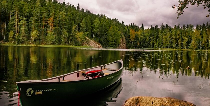 Green Canoe on a calm and serene lake with a peaceful view in Nuuksio in Finland.