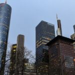 An image of Frankfurt’s skyline with modern skyscrapers, historic buildings, and a clear evening sky.