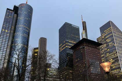 An image of Frankfurt’s skyline with modern skyscrapers, historic buildings, and a clear evening sky.