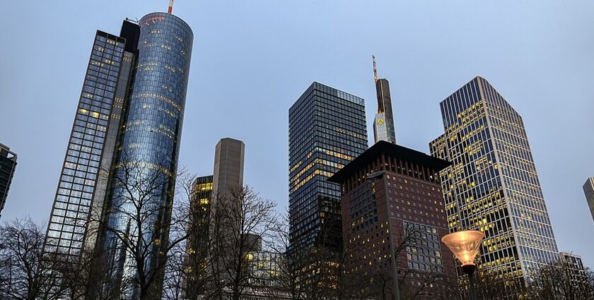 An image of Frankfurt’s skyline with modern skyscrapers, historic buildings, and a clear evening sky.