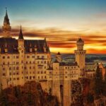 An image of a majestic castle with towers at sunset in Schwangau, Germany.