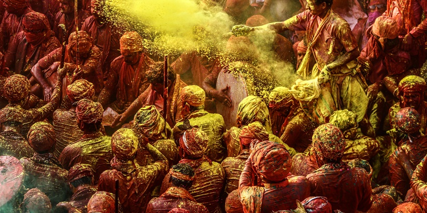 People throw colours together while celebrating Holi at the Banke Bihari Temple, Vrindavan.