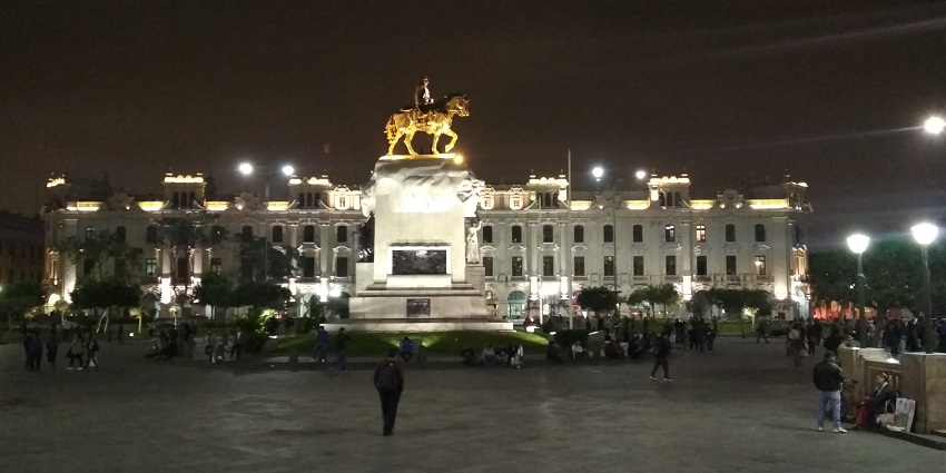Enjoy Lima Peru nightlife at the historic square showcasing grand colonial buildings, a striking statue, and vibrant cultural energy
