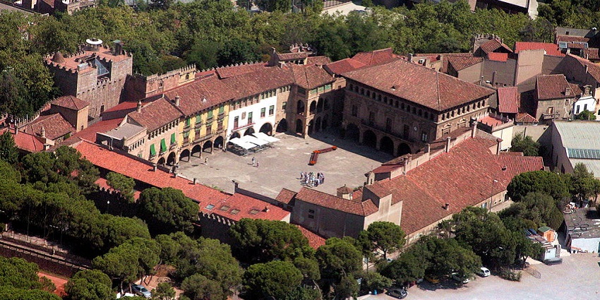 An aerial view of Poble Espanyol shows a group of visitors standing in its courtyard.
