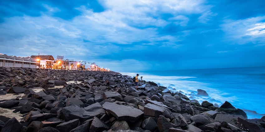 A stunning picture of a rocky beach in Pondicherry with the blue sky merging into the seawater
