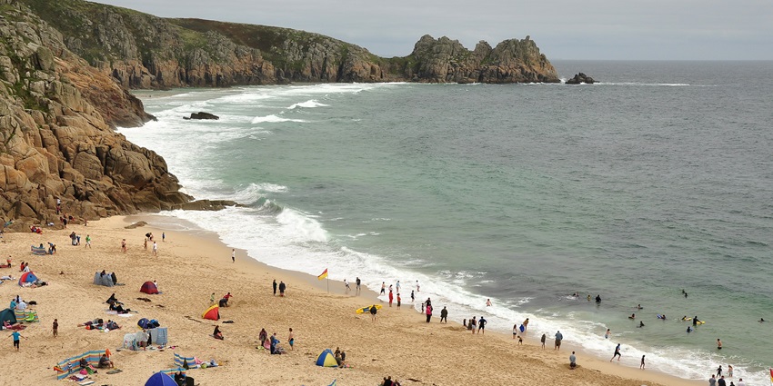A picturesque Porthcurno Beach with turquoise waters and dramatic cliffs in Cornwall.