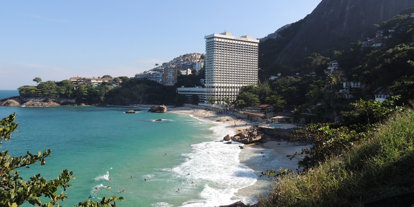An image of Praia de Sao, with water crashing to the shorelines, greenery all around