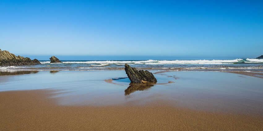 Praia do Carvalhal is an unspoiled beach is surrounded by sand dunes and greenery.