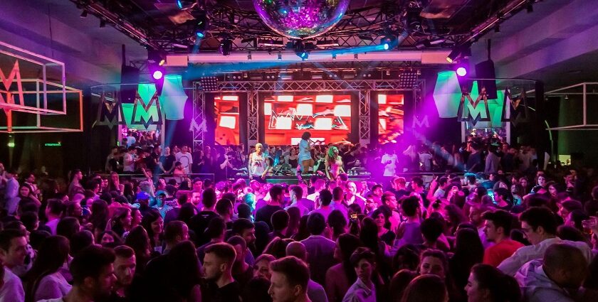 A view of a lively crowd dancing and celebrating together in a popular Pune bar.