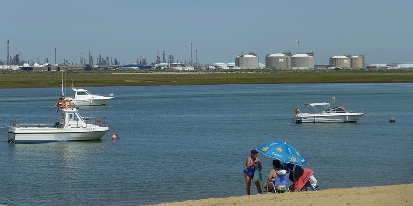 Image of beach and sport boats in Punta Umbría in front of the industrial scenery of La Rábita