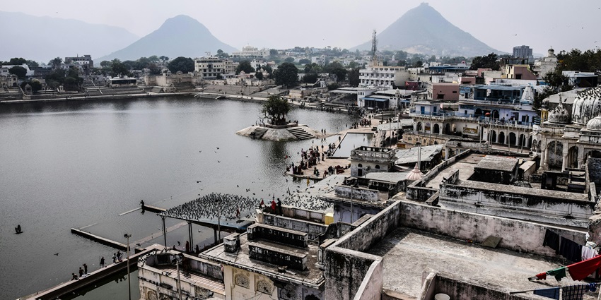An image of sacred Pushkar Lake with ghats and temples, reflecting in the still water.