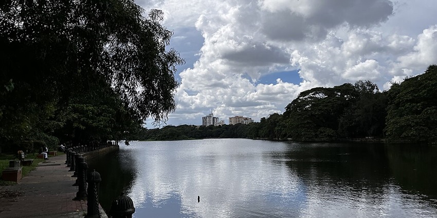 Rabindra Sarobar with a small water body, reflections of the cloudy sky and greenery.