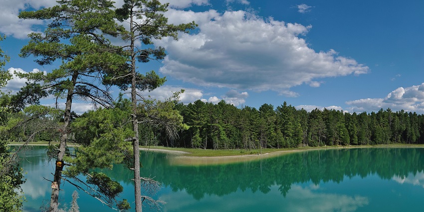 An image of Railadevi Lake with reflections on the water.