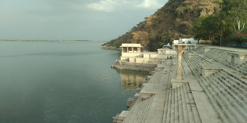 Wide view of Rajsamand lake with a long stone stairway leading down to the water
