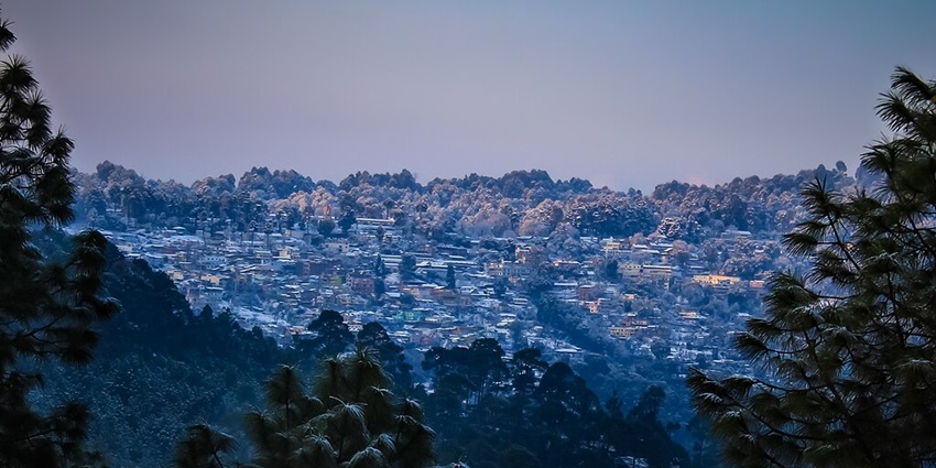 An image showing Ranikhet in winter, with snow-covered landscapes and amazing Himalayan views