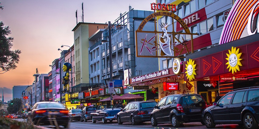 An image showing the Reeperbahn at dawn, with quiet streets and soft morning light.