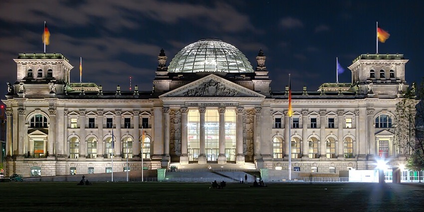 Image of the Berlin Reichstag building at night, a popular destination near Holocaust Museum Berlin.