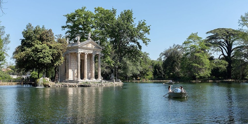 Two girls sailing on a rowboat on a quiet lake at Villa Borghese, a top place in Rome