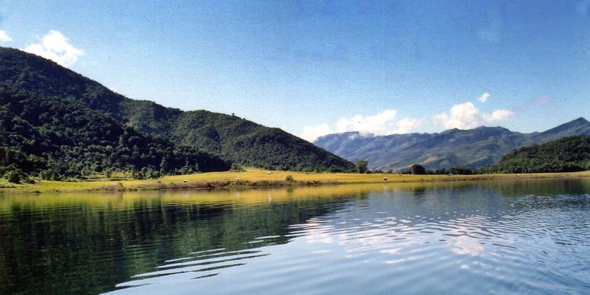 Rih Dil Lake with the reflections of the hills on the lake and distant green mountains
