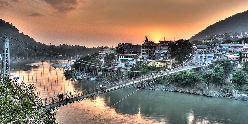An image of Rishikesh, Lakshman Jhula, a suspension bridge over the Ganges River, with scenic views