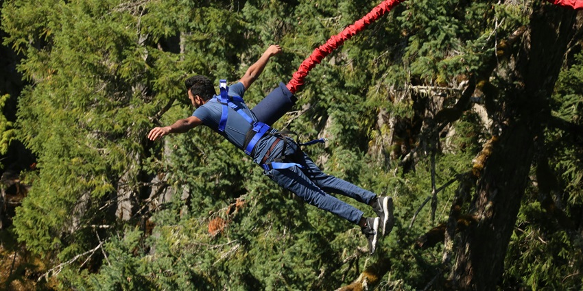 An Image of a man bungee jumping towards the ground resembling bungee jumping in Rishikesh
