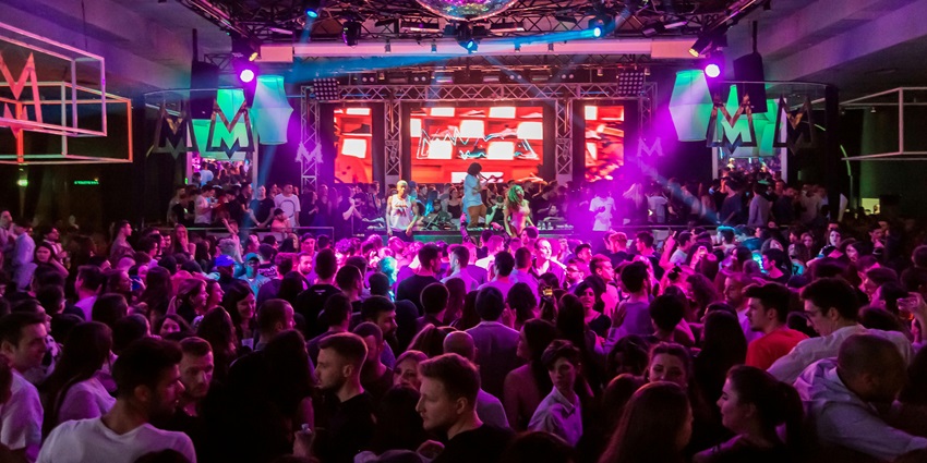 A crowd enjoying the rock music environment on floor similar to vibes in Rock Café Riga