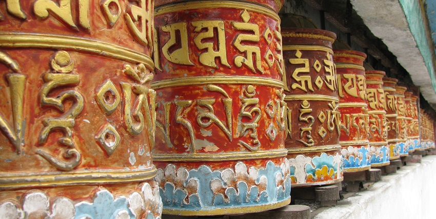 Colourful prayer wheels inscribed with Tibetan scripts at Rumtek Monastery in Sikkim.