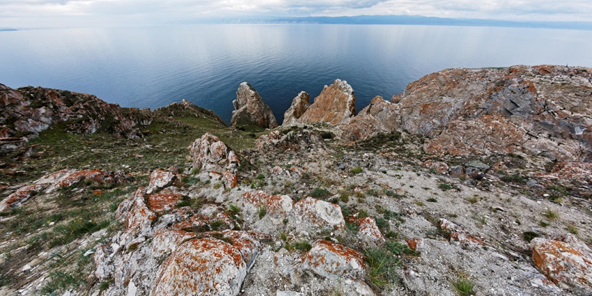 An image of Sagaan Khushun Cape, a dramatic white marble cliffs meeting deep blue waters.