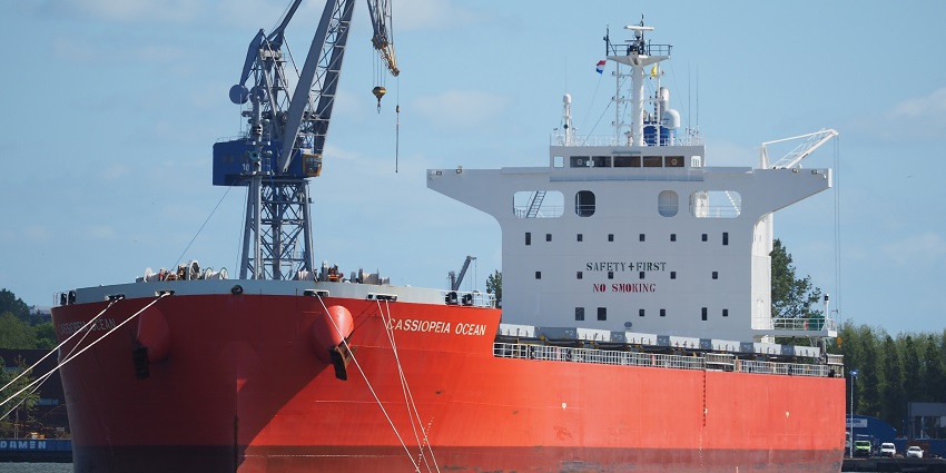 A red and white ship sails in the ocean near the Maritime Museum in India.