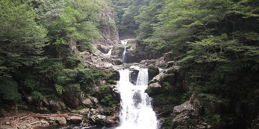 Sandan Falls near Hiroshima Peace Memorial Museum surrounded by lush greenery.