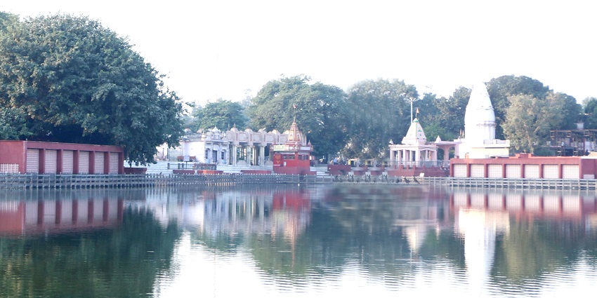 Sannihit Sarovar lake with sacred waters, temple structures, and a serene ambiance.
