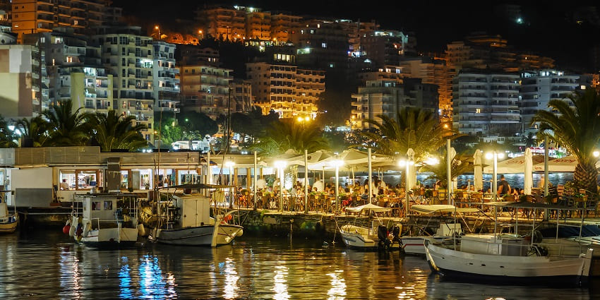 Tourists explore Albania’s nightlife excitingly by dining near Saranda Beach.
