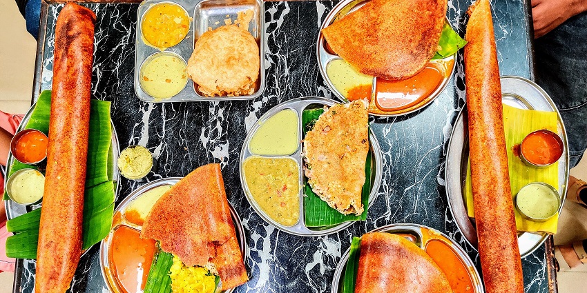 Different varieties of traditional South Indian food served on a table.