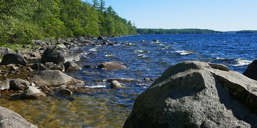 Clear blue waters at the shoreline of Sebago Lake in Cumberland County, Maine, USA.
