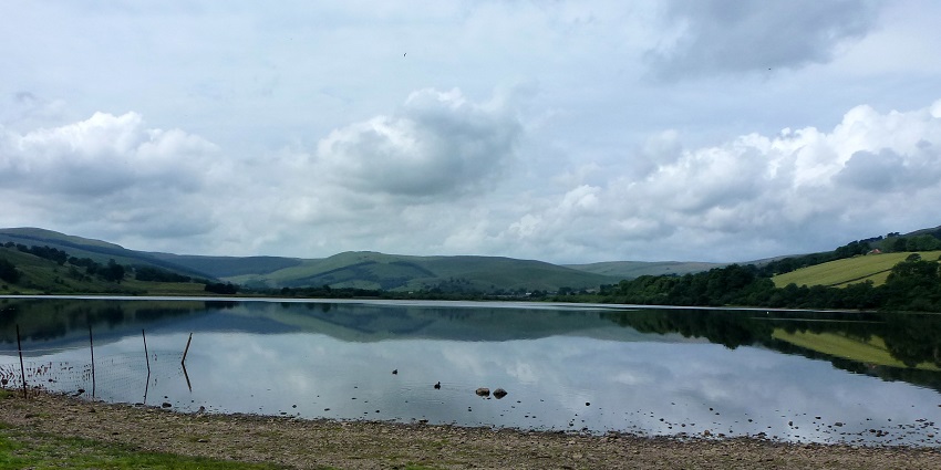 Semerwater sports where a man is performing water skiing attached to a blue boat