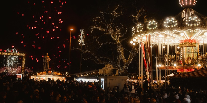 An image of a lively night scene featuring a carousel, lights, and a cheerful crowd celebrating Christmas, just like Shillong’s Christmas celebrations.