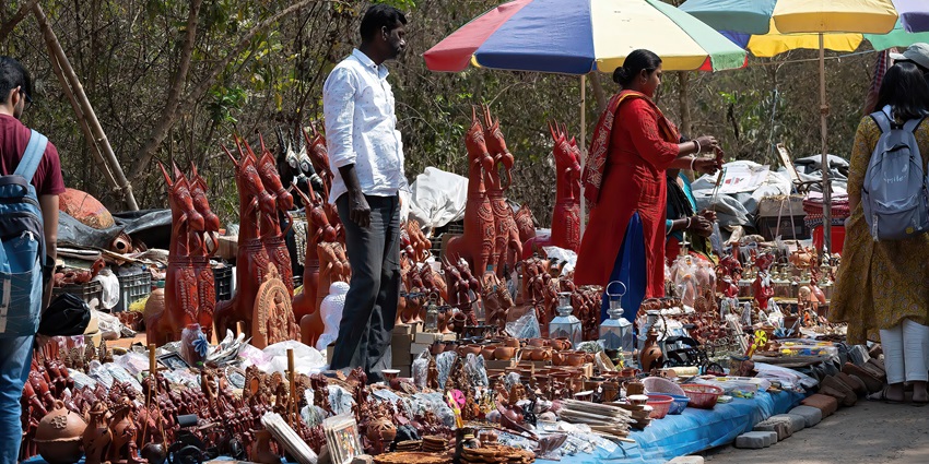 A colourful display of handcrafted Pattachitra scrolls, appliqué lanterns, and palm leaf etchings at a local artisan market, one of the things to see in Chilika Lake.