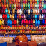 A view of assorted colourful women's flats hanging in a store in the handicraft market.