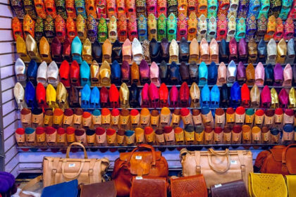 A view of assorted colourful women's flats hanging in a store in the handicraft market.