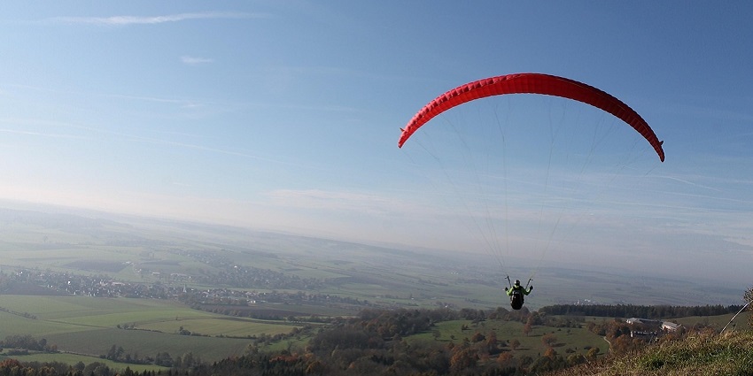 An image showing skydiving with a parachute over mountains, similar to Skydive Nuggets.