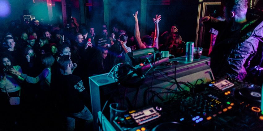 An image with people dancing inside a bar, resembling the vibrant atmosphere of Slakthuset