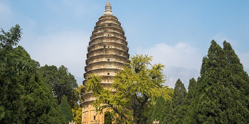 Songyue Pagoda with its ancient, towering structure surrounded by lush greenery and clear skies