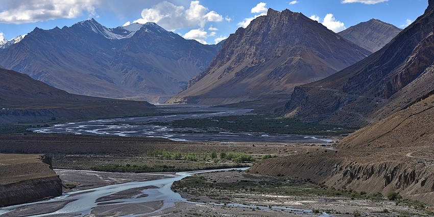 An image showing the Spiti River flowing through Kaza, Himachal, amidst rugged mountain landscapes.