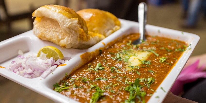 Pav Bhaji served on a tray by a street vendor representing the local street food essence.