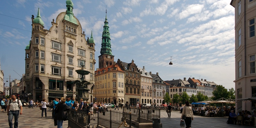 An Image of the Gucci shop in Stroget, with people walking in the street during the day.