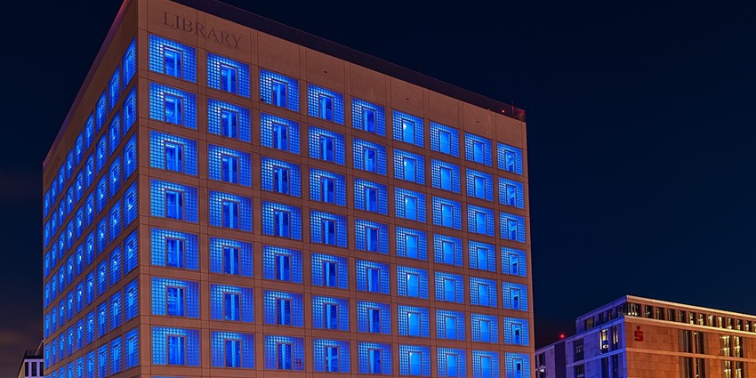 An image showing the illuminated Stadtbibliothek Stuttgart building at night.