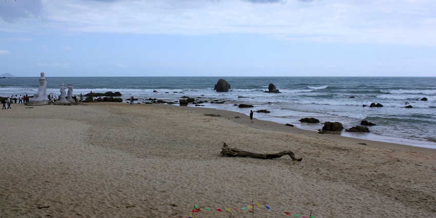 Calm waves under the cloudy sky of Sun and Moon Bay, one of the best beaches in China