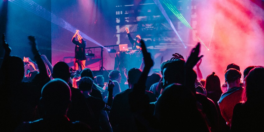 An image of crowd enjoying the beats of DJ resembling the vibes of the Sweet Club